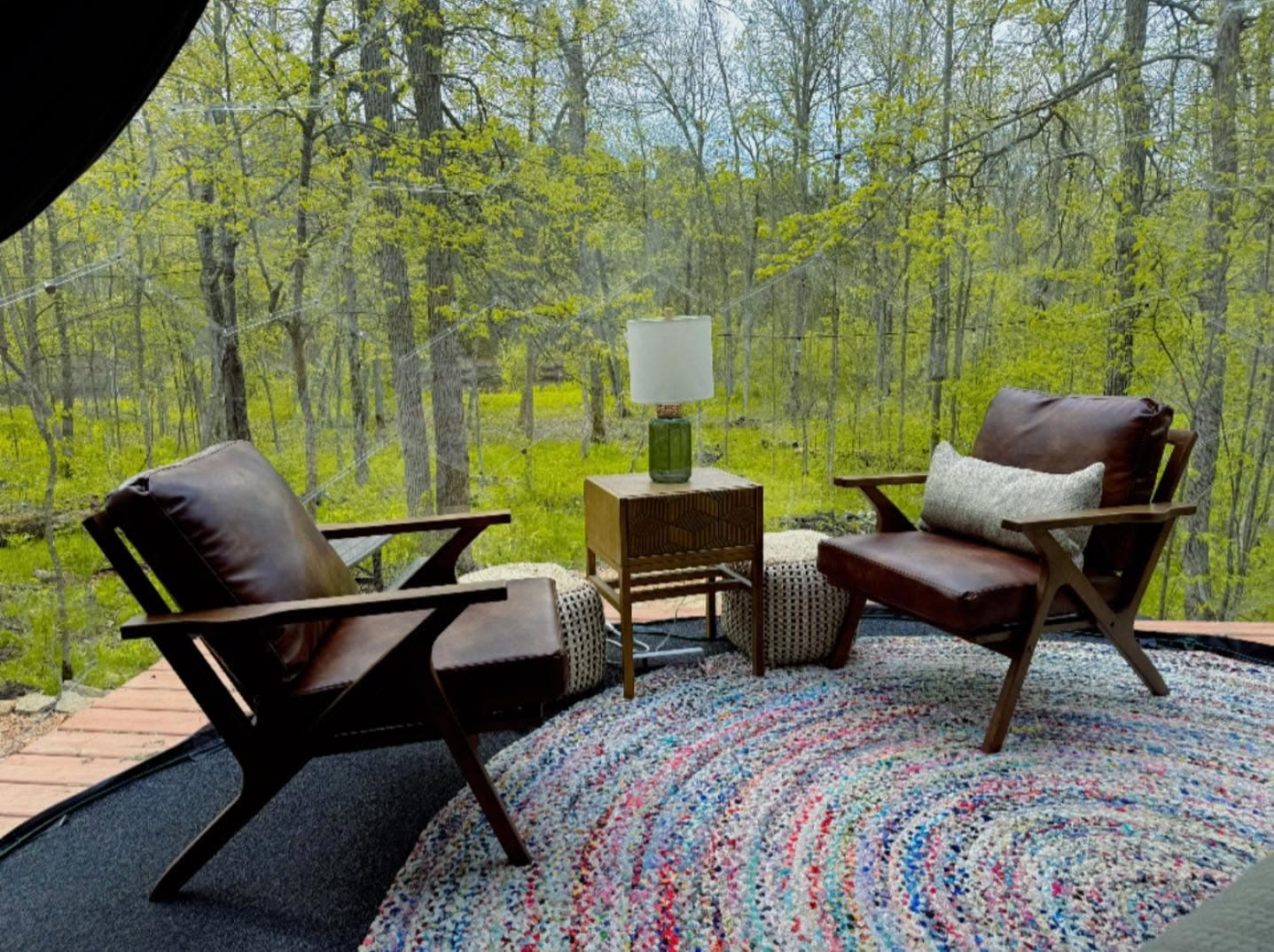 Interior of glamping space with mid-century furniture and forest views